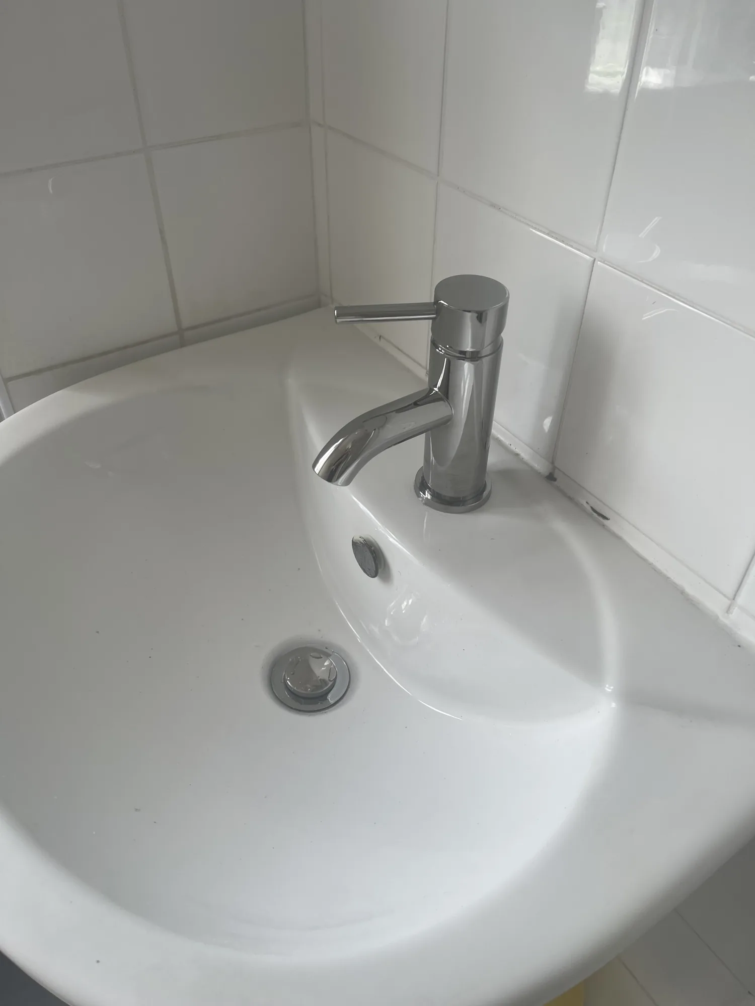 New chrome basin mixer tap fitted to a white sink